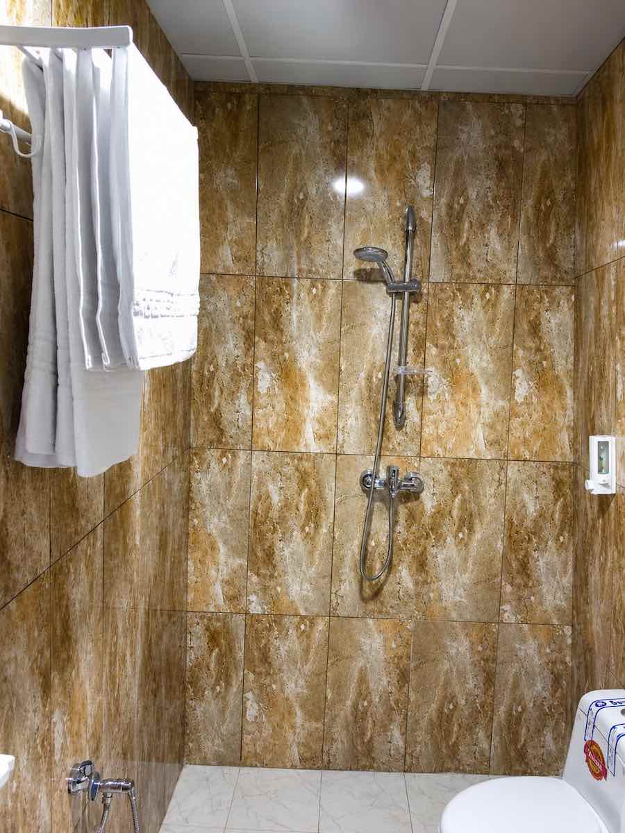 Shower Area in Hormuz Family Suite with Modern Bathroom and Fresh Towels